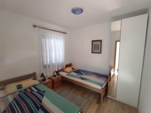 a small bedroom with two beds and a mirror at Apartments "Mulo" beachfront in Vrsi