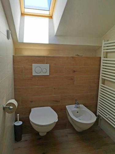a bathroom with a toilet and a sink and a skylight at Maso Sveseri in Montesover