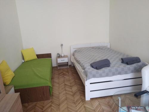 een kleine slaapkamer met een bed en een groene bank bij Adrienn apartment in Boedapest