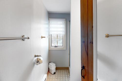 ein Badezimmer mit Toilette und Fenster in der Unterkunft Cape Cod Beach Cottage in Dennis