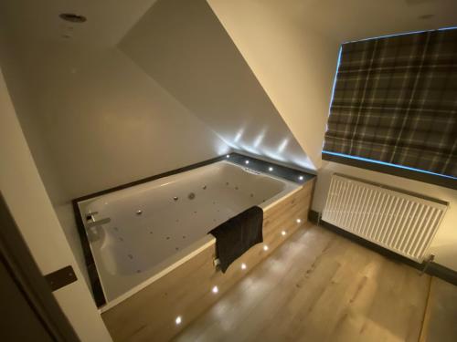 een groot bad in een kamer met een raam bij holidayhomemoffat,com (Stable Cottage) in Moffat