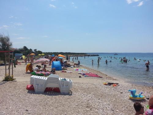 a beach with a bunch of people in the water at Apartment Mirna in Skunca