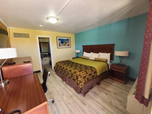 um quarto de hotel com uma cama e uma secretária em America's Value Inn em Tulsa