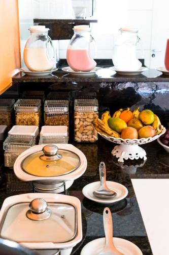 eine Küchentheke mit Obstschalen und Behältern mit Lebensmitteln in der Unterkunft Pousada Mirante da Praia in São Miguel do Gostoso