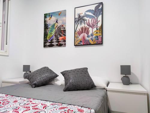 a bedroom with a bed and three pictures on the wall at Los Cristianos - heated swimming pool air-conditioned in Los Cristianos