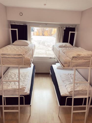three bunk beds in a room with a window at Uppsala City Hostel in Uppsala