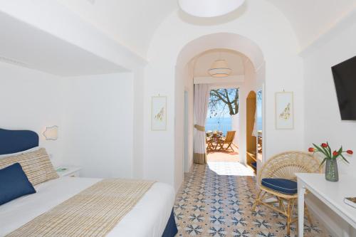 a hotel room with a bed and a table and chairs at Villa Fortuna in Positano