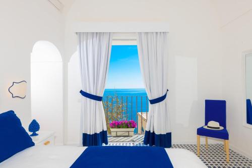 a bedroom with a bed and a view of the ocean at Villa Fortuna in Positano