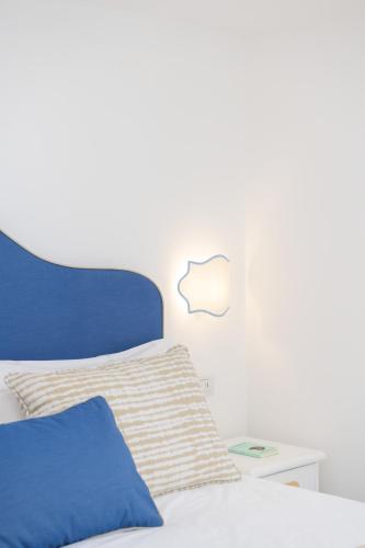 a bed with a blue headboard and a side table at Villa Fortuna in Positano