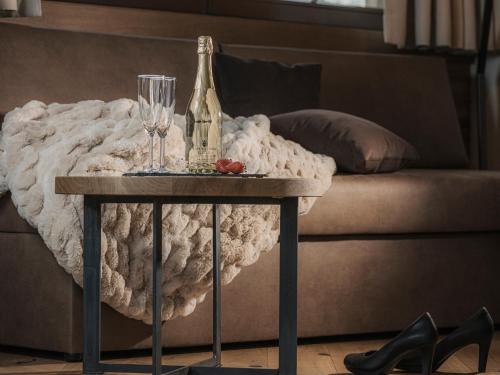 a bottle of champagne and a glass on a table next to a couch at Aparthotel Stacherhof in Fügen