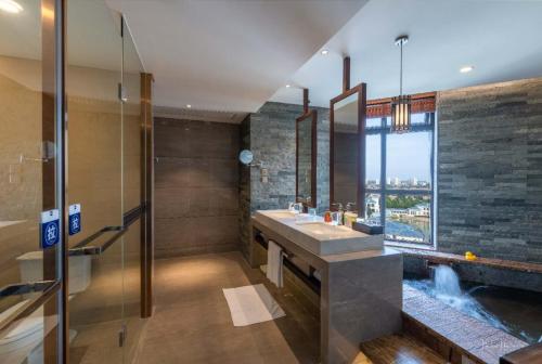 a bathroom with two sinks and a large window at Grand Metropark Longxi Conference Center Beijing in Beijing