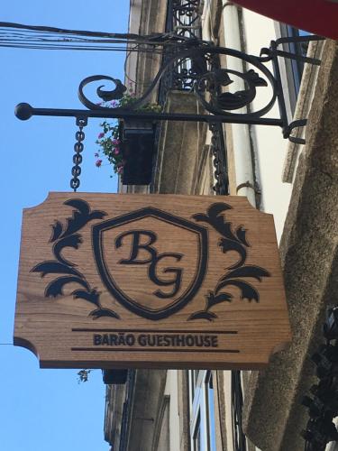 a wooden sign hanging from the side of a building at Barão Guesthouse in Vouzela