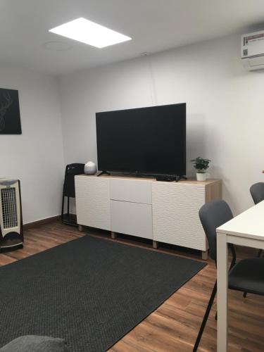 a living room with a flat screen tv on a white cabinet at Barão Guesthouse in Vouzela