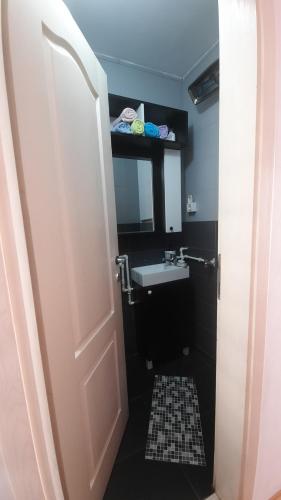 a bathroom with a sink and a toilet and a door at Apartmani LolaNola in Vrnjačka Banja