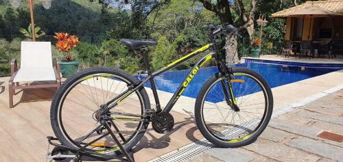 a bike is parked next to a pool at Vaca do Brejo, piscina aquecida, sauna, A/C quente in Petrópolis