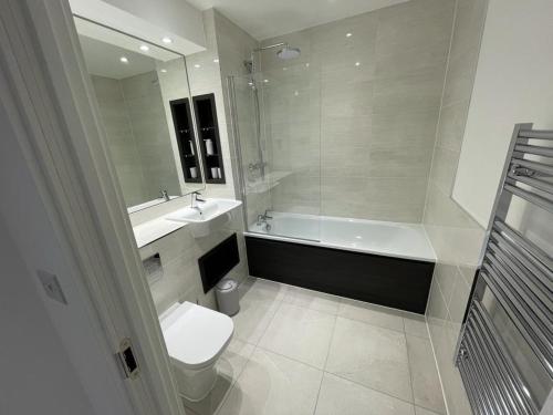 a bathroom with a toilet and a sink and a bath tub at Bexleyheath, Regal Walk in Bexleyheath