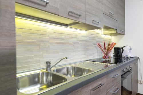 a kitchen with a stainless steel sink and wooden cabinets at A letto nell'Arte in Ascoli Piceno