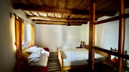 1 dormitorio con 2 camas y techo de madera en Káli Kerted Vendégházak Monoszló Mariska néni háza en Monoszló