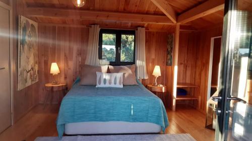 a bedroom with a bed in a room with wooden walls at Ying Yang Monte da Lua in Comporta