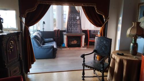 a living room with a chair and a fireplace at Forever São Brás in São Brás de Alportel
