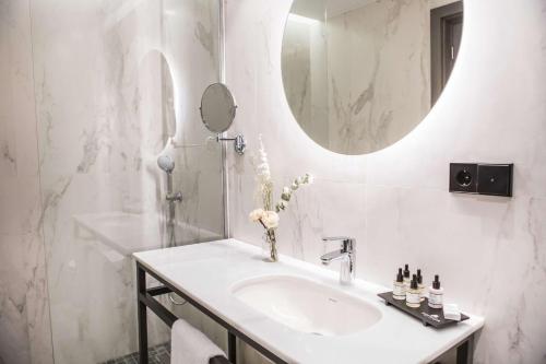 a white bathroom with a sink and a mirror at Best Western Premier Sofraga Palacio in Ávila