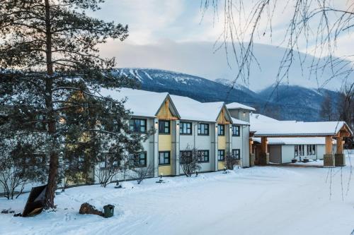 a house in the snow with snow covered trees at Prestige Hudson Bay Lodge & Conference Centre, WorldHotels Crafted Collection in Smithers
