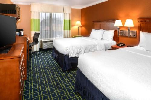 a hotel room with two beds and a flat screen tv at SureStay Hotel by Best Western Ontario Airport in Ontario