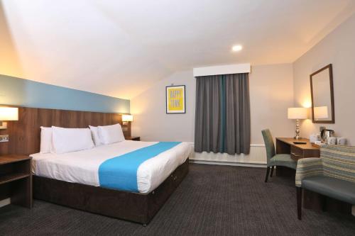 a hotel room with a bed and a desk at The Jephson Hotel; BW Signature Collection in Leamington Spa