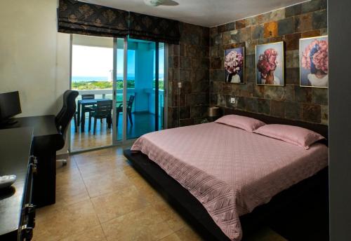 a bedroom with a bed and a desk and a balcony at BlueLagoon Apartamento en Playa Blanča in Playa Blanca