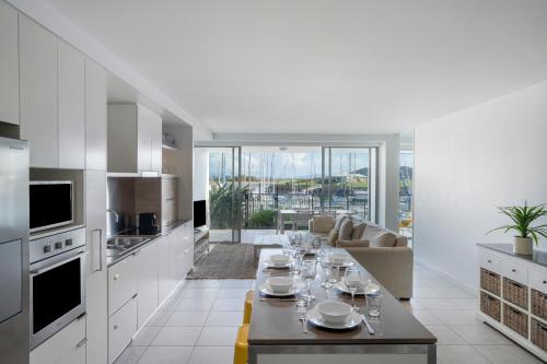 a white kitchen with a table with glasses on it at Peppers Blue on Blue in Nelly Bay