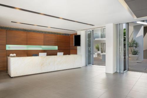 an office lobby with a reception desk and a tv at Peppers Blue on Blue in Nelly Bay