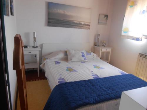 a bedroom with a bed with a blue blanket at Casa na Praia do Mindelo in Mindelo