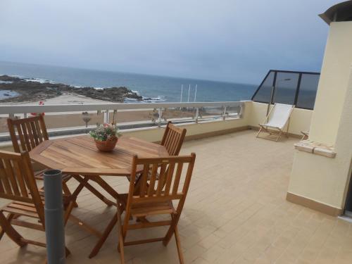 a table and chairs on a balcony with the ocean at Casa na Praia do Mindelo in Mindelo
