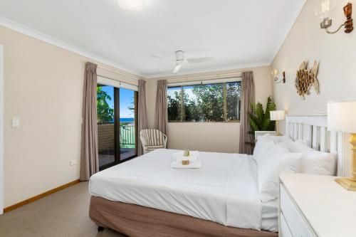 a bedroom with a large white bed and a window at Sea Gaze Apartments by Kingscliff Accommodation in Kingscliff