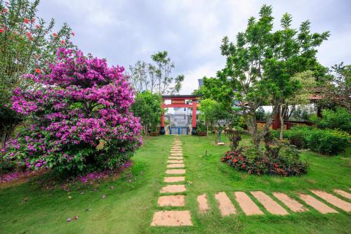 a garden with purple flowers and a pathway at Bonjour Da Lat Hotel in Da Lat