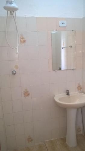 a bathroom with a sink and a mirror at Pousada Iguape in Iguape
