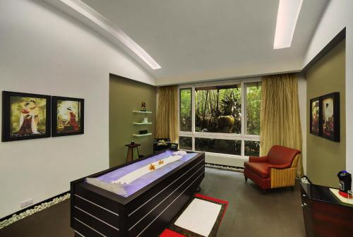 a bedroom with a bed and a chair and a window at Mayfair Spa Resort & Casino in Gangtok