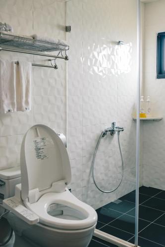 a bathroom with a toilet and a shower at Destination Inn in Magong