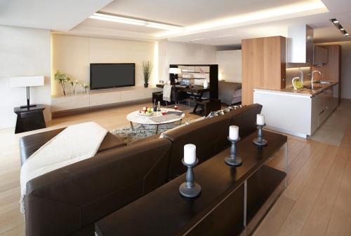 a living room with a brown couch and a kitchen at The Classic 500 Pentaz Executive Residence in Seoul
