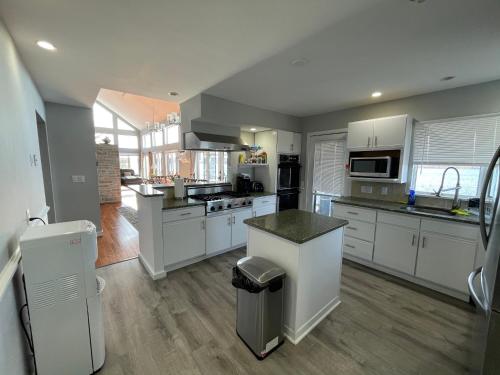 a large kitchen with white cabinets and a counter at Spectacular home with a amazing ocean - river view in Groton