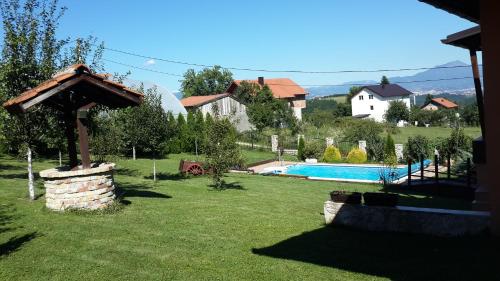 une cour avec une piscine et une maison dans l'établissement Vila Sani, à Sarajevo
