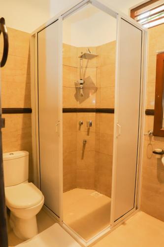 a bathroom with a shower with a toilet at Sathmin Villa in Ahangama