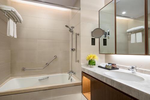 a bathroom with a tub and a sink at Somerset Emerald City Suzhou in Suzhou