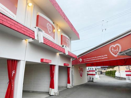 Tamatsuにあるfeelの赤白の看板が貼られた建物
