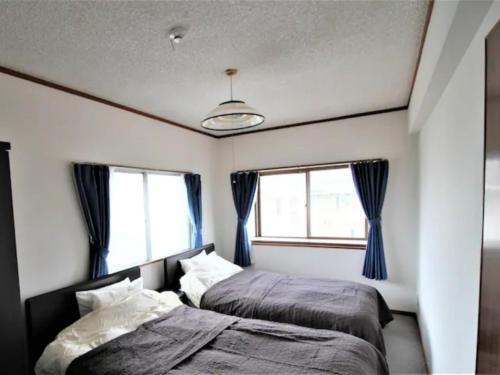 um quarto com 2 camas e 2 janelas em Maison Ota Building A Building B - Vacation STAY 11098 em Takamatsu