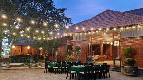 a patio with a table and chairs and lights at Orchard Home Nam Cat Tien in Cat Tien