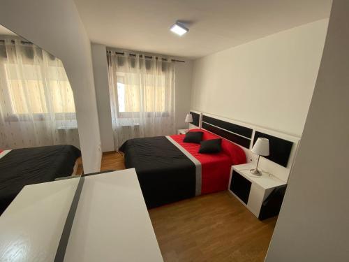 um quarto com duas camas vermelhas e pretas em Piso céntrico, con amplia terraza, 3 dormitorios em Ribeira