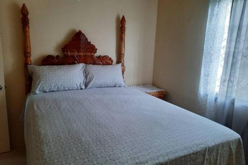 1 cama con cabecero de madera en un dormitorio en Rick's Reggae Villa en Montego Bay