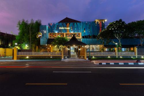 a building with a blue facade at night at Jogja Village in Yogyakarta