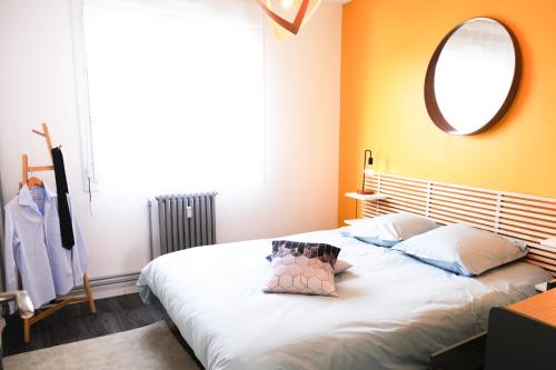 um quarto com uma grande cama branca e um espelho em Le Chambord 2 em Laval